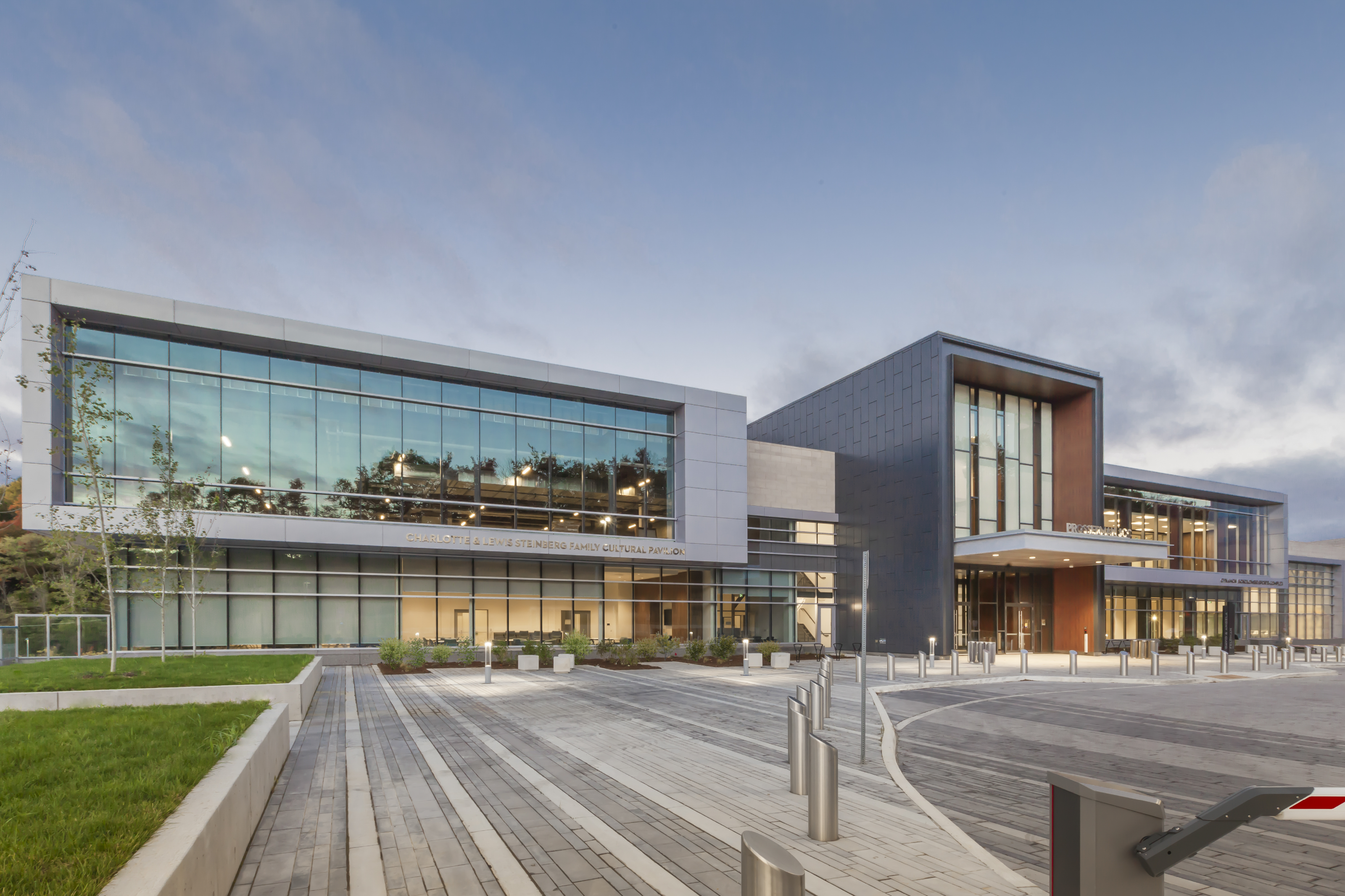 Large, glass and metal building made up of three intersecting rectangular volumes. On the left, a wide, squat silver volume faced with glass; in the middle, a tall narrow black volume with a projecting canopy over the main entrance; on the right, another wide silver volume faced with glass.